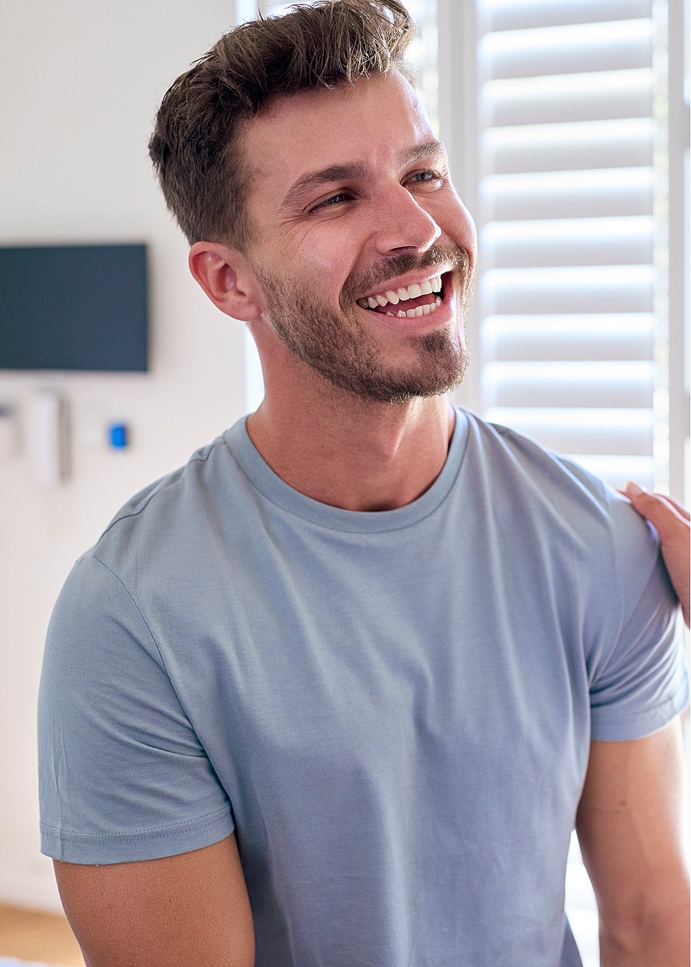 NYC minimally invasive surgery model in casual outfit, bright room.